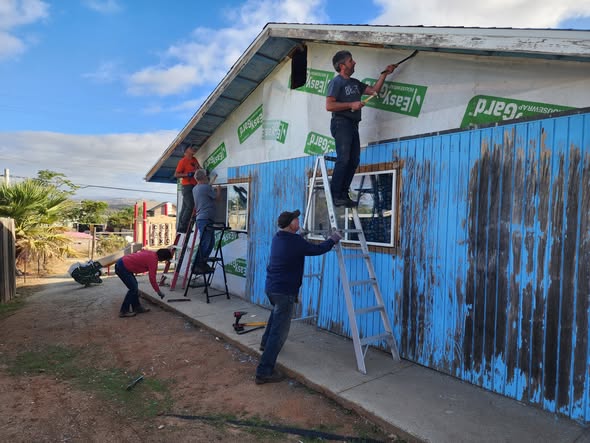 Volunteers replacing siding