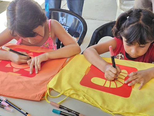 Two children decorate colorful bags together